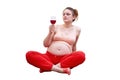 Pregnant woman doing fitness at home and looking at red wine in a gla Royalty Free Stock Photo