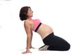 Pregnant woman doing floor exercises on white background