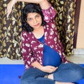 Pregnant woman doing Pregnancy yoga pose comfortable at home with belly, Pregnant woman practicing simple yoga steps at home, Royalty Free Stock Photo