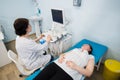 Pregnant woman doing ultrasound scan in the prenatal clinic, mother worried about health of her future baby, happy Royalty Free Stock Photo