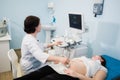 Pregnant woman doing ultrasound scan in the prenatal clinic, mother worried about health of her future baby, happy Royalty Free Stock Photo