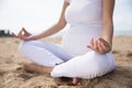 Pregnant woman doing yoga in the beach Royalty Free Stock Photo