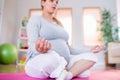 Pregnant woman doing yoga on exercise mat Royalty Free Stock Photo