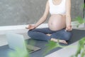 Pregnant Woman Doing Yoga On Exercise Mat. meditating for near-term childbirth of meditating attractive Pregnant female recreation