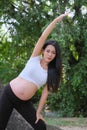 Pregnant woman doing yoga exercise in nature on summer Royalty Free Stock Photo