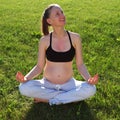 Pregnant woman doing yoga outdoors Royalty Free Stock Photo