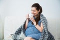 Pregnant woman drink tea and under warm cozy plaid at home Royalty Free Stock Photo