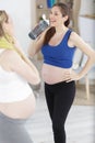 pregnant woman drinking water after exercising