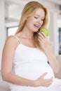 Pregnant woman eating apple and smiling Royalty Free Stock Photo