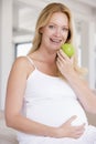 Pregnant woman eating apple and smiling Royalty Free Stock Photo