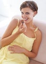 Pregnant woman, eating chocolate and happy in home, alone and enjoying delicious pregnancy craving. Good mood, comfort Royalty Free Stock Photo