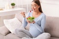 Pregnant Woman Eating Vegetable Salad Sitting On Couch At Home Royalty Free Stock Photo