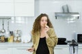 pregnant woman eating green apple fruit, holding knife, look vacant, looking space in kitchen with copy space. beautiful caucasian Royalty Free Stock Photo