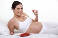 A pregnant woman eating strawberries Royalty Free Stock Photo