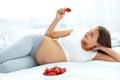 Pregnant Woman Eating Strawberry at home. Healthy Food Concept. Royalty Free Stock Photo