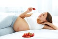 Pregnant Woman Eating Strawberry at home. Healthy Food Concept. Royalty Free Stock Photo