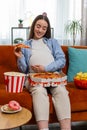 Pregnant woman eating unhealthy junk fatty fast food pizza popcorn crisp watching movie at home Royalty Free Stock Photo