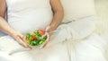 A pregnant woman eats a salad with vegetables. Selective focus Royalty Free Stock Photo