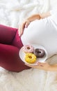 A pregnant woman eats sweet donuts. Selective Focus Royalty Free Stock Photo