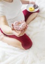 A pregnant woman eats sweet donuts. Selective Focus Royalty Free Stock Photo