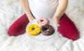 A pregnant woman eats sweet donuts. Selective Focus Royalty Free Stock Photo