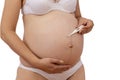 Pregnant woman with a electronic thermometer in hand