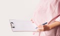 Pregnant woman with empty white paper as medical card, agreement blank. Template for text Royalty Free Stock Photo