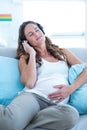 Pregnant woman enjoying music at home Royalty Free Stock Photo