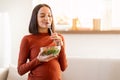 Pregnant woman enjoying vegetable salad meal posing with bowl indoor Royalty Free Stock Photo
