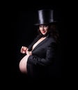 Pregnant woman in evening dress and hat cylinder
