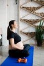 Pregnant woman exercing yoga at home. Pregnancy yoga and fitness.