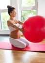 Pregnant woman exercising with ball on yoga mat Royalty Free Stock Photo
