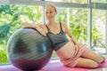 Pregnant woman exercising on fitball at home. Pregnant woman doing relax exercises with a fitness pilates ball. Against Royalty Free Stock Photo