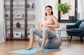 Pregnant woman exercising on fitness ball at home Royalty Free Stock Photo