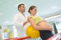 pregnant woman exercising with physiotherapist in birthing school Royalty Free Stock Photo