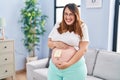 Pregnant woman expecting a baby wondering sex smiling and laughing hard out loud because funny crazy joke Royalty Free Stock Photo