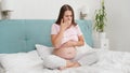 Pregnant woman feeling sick with nausea sitting on bed at morning. Intoxication during pregnancy