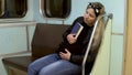 A pregnant woman fell asleep with a book in her hands on a subway train. Old subway train car