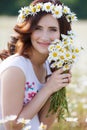 A pregnant woman in a field with a bouquet of white daisies Royalty Free Stock Photo