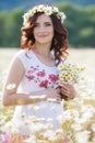 A pregnant woman in a field with a bouquet of white daisies Royalty Free Stock Photo