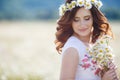 A pregnant woman in a field with a bouquet of white daisies Royalty Free Stock Photo