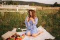 Pregnant woman in the field eating fresh backed crispy croissant. Healthy food. Young woman eats very appetizing