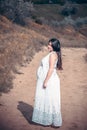 Pregnant woman on the field road Royalty Free Stock Photo