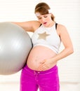 Pregnant woman with fit ball and touching belly Royalty Free Stock Photo