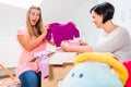 Pregnant woman and friend sharing baby clothes Royalty Free Stock Photo