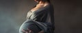 A Pregnant Woman Gently Cradles Her Prominent Belly During The Final Months Of Pregnancy Radiating Maternal Grace