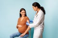 Pregnant Woman Getting Vaccinated Against Covid-19 Over Blue Background