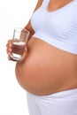 Pregnant woman and glass of water. Vertical photo of belly. Royalty Free Stock Photo