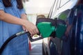 Pregnant woman hand pumping gasoline fuel in car at gas station Royalty Free Stock Photo