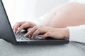Pregnant women hand typing on keyboard on notebook to searching newborn baby . Using a laptop Royalty Free Stock Photo